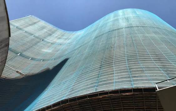 The Copan building seen from below, its long curved façade rising against a clear blue sky.
